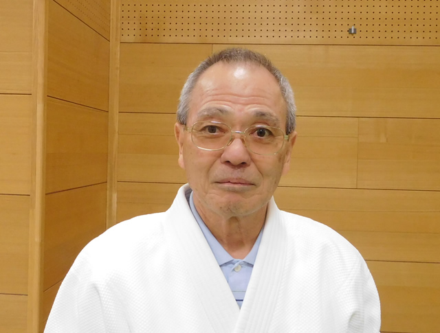 稽古着を着た立っている姿の斎藤先生の上半身